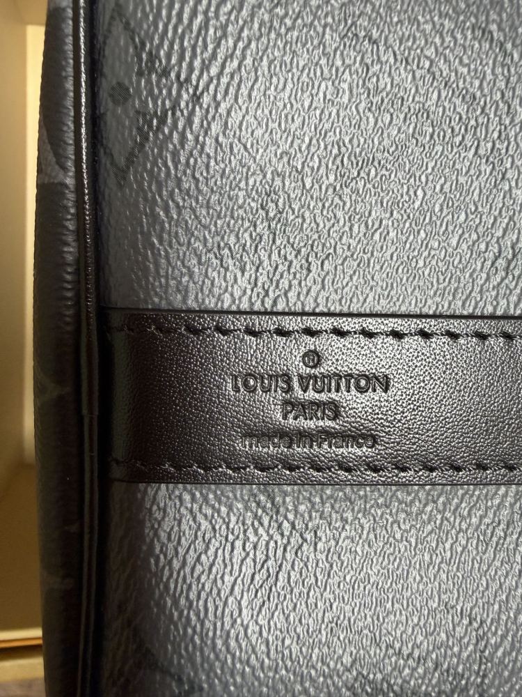 The Louis Vuitton Keepall Bandoulière 35 bag features the classic Monogram Eclipse black and grey canvas.