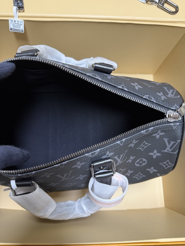 The Louis Vuitton Keepall Bandoulière 35 bag features the classic Monogram Eclipse black and grey canvas.