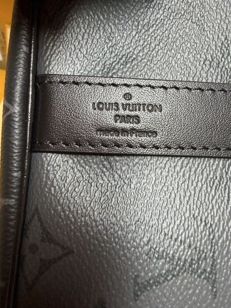 The Louis Vuitton Keepall Bandoulière 35 bag features the classic Monogram Eclipse black and grey canvas.