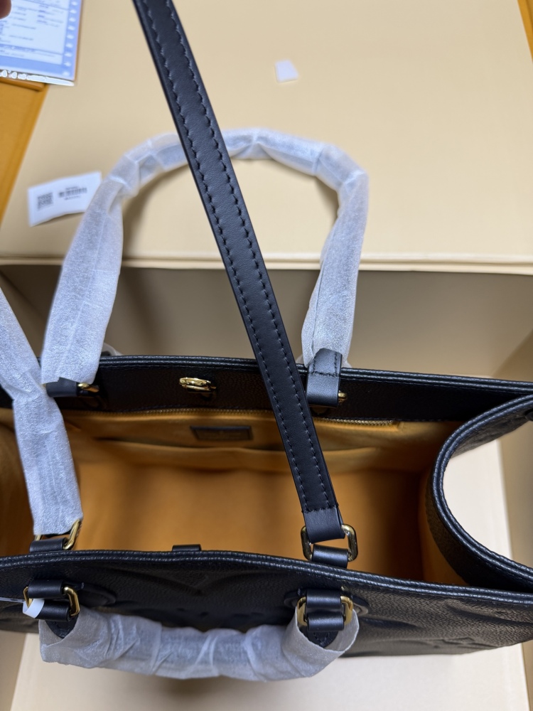 The Louis Vuitton Onthego MM tote bag, featuring an all-black version crafted from embossed Monogram Empreinte cowhide.