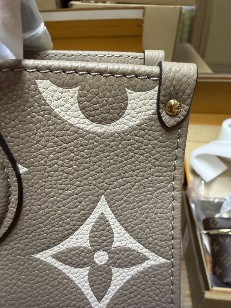 Louis Vuitton OnTheGo East-West Small Handbag, featuring a Grey/White colorway in Monogram Empreinte embossed cowhide.