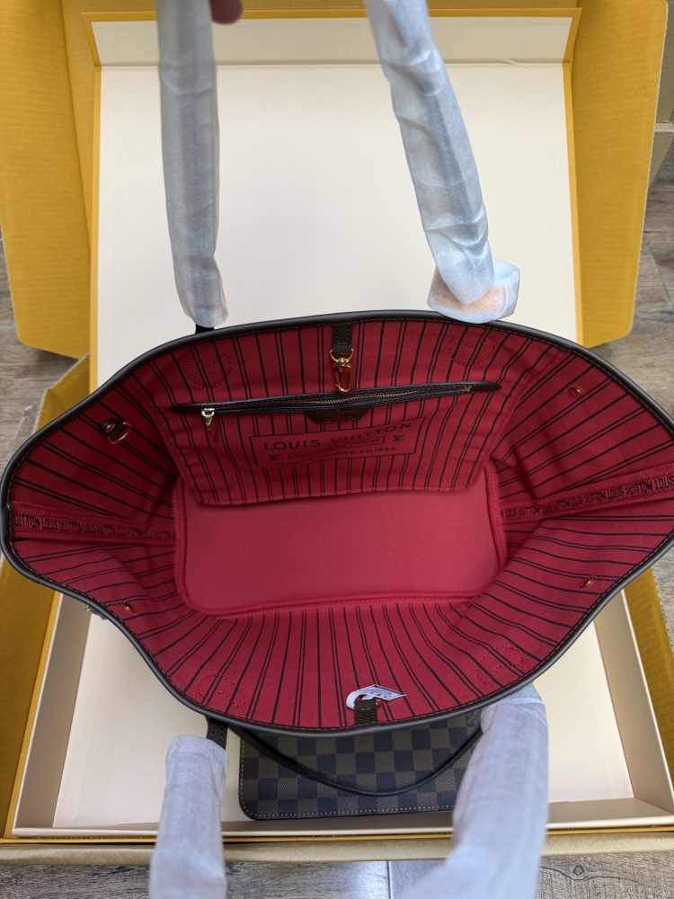 The Louis Vuitton Neverfull MM medium tote bag features the classic Damier Ebene brown checkered canvas, paired with the iconic red striped lining.