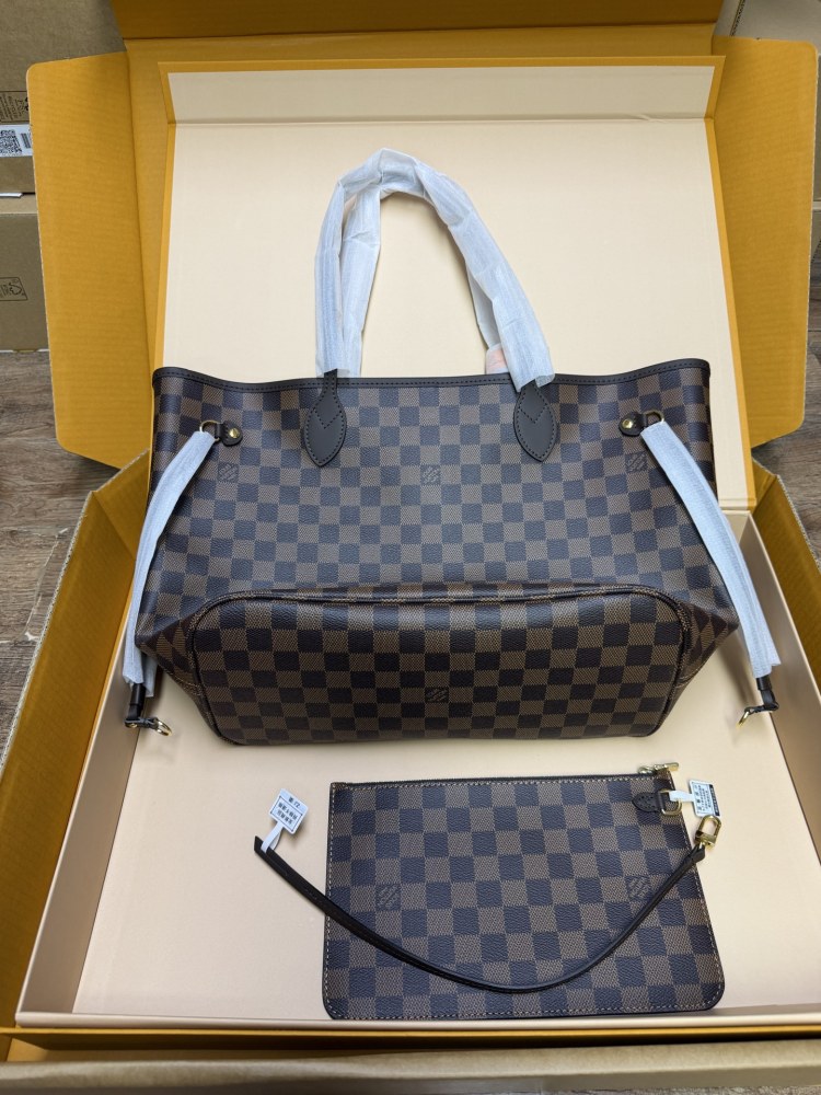 The Louis Vuitton Neverfull MM medium tote bag features the classic Damier Ebene brown checkered canvas, paired with the iconic red striped lining.