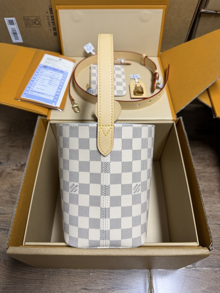 The Louis Vuitton Nano Bucket bag features the brand's classic Damier Azur white checkered canvas, paired with a light blue lining.