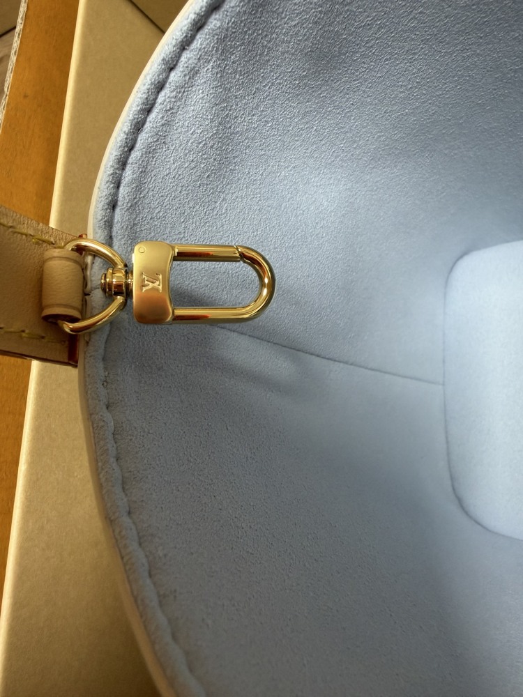 The Louis Vuitton Nano Bucket bag features the brand's classic Damier Azur white checkered canvas, paired with a light blue lining.