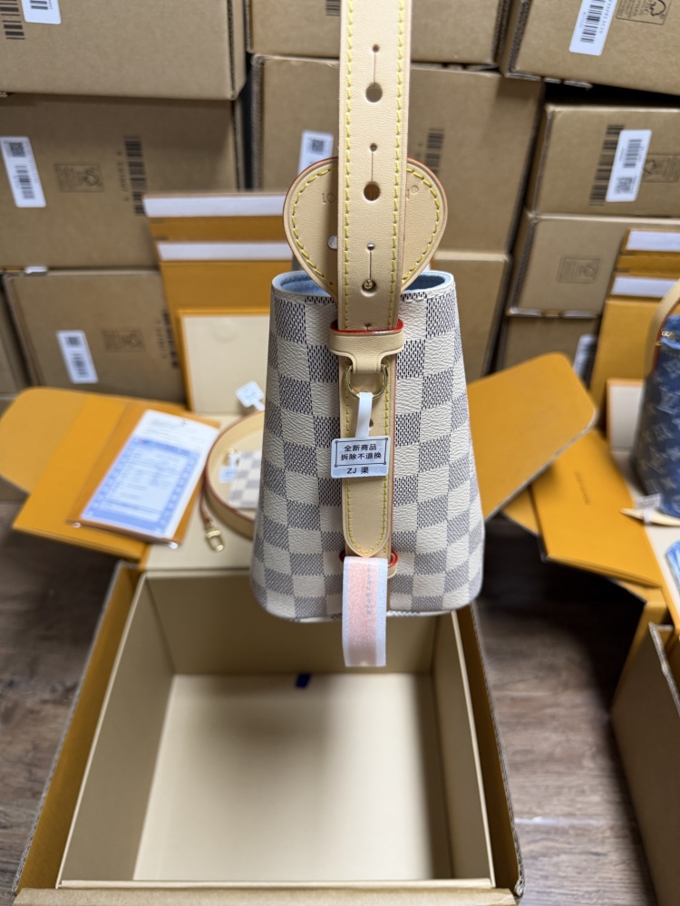 The Louis Vuitton Nano Bucket bag features the brand's classic Damier Azur white checkered canvas, paired with a light blue lining.