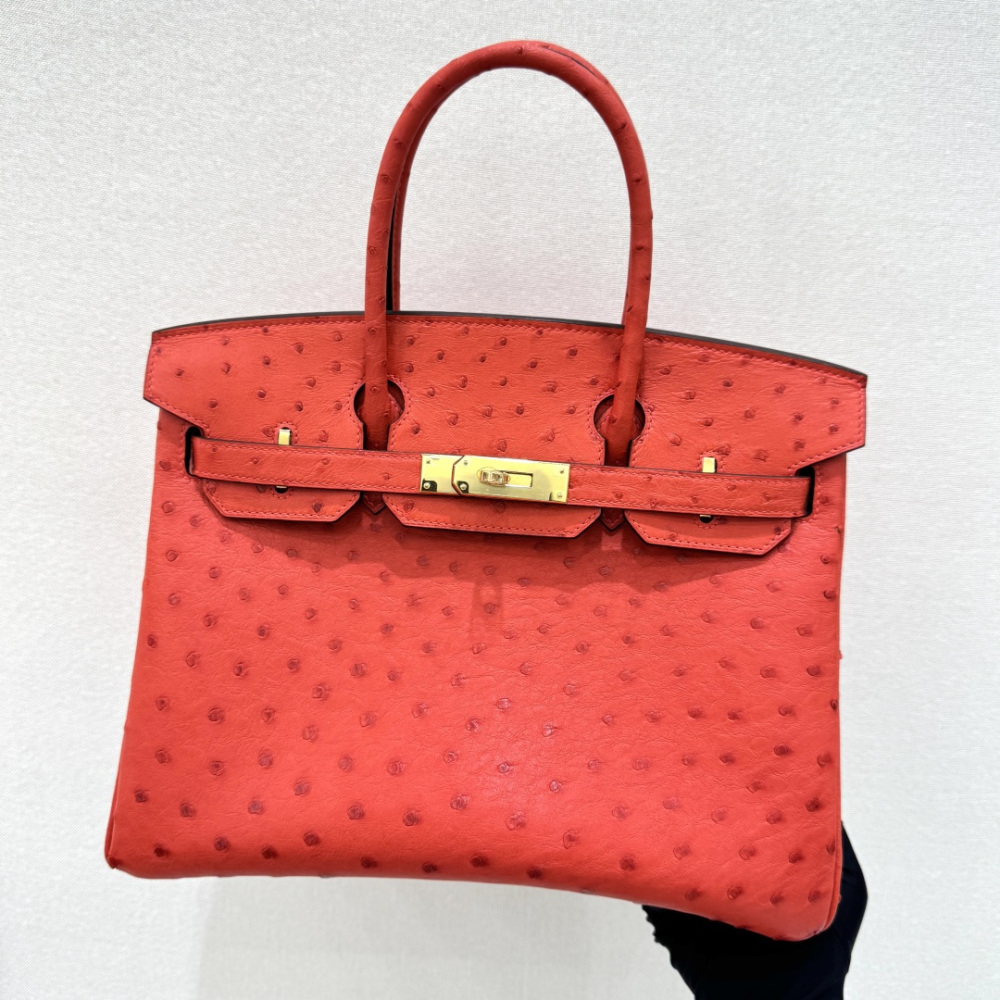 The Hermès Birkin 30 Ostrich Handbag—featuring a striking true red hue (reminiscent of tomato or flame red) paired with gold hardware—stands as one of the brand's most instantly recognizable and coveted flagship models crafted from exotic leather.