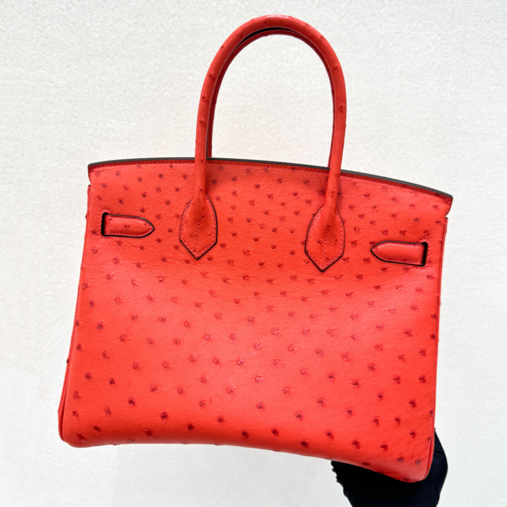 The Hermès Birkin 30 Ostrich Handbag—featuring a striking true red hue (reminiscent of tomato or flame red) paired with gold hardware—stands as one of the brand's most instantly recognizable and coveted flagship models crafted from exotic leather.