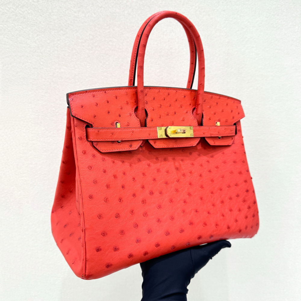 The Hermès Birkin 30 Ostrich Handbag—featuring a striking true red hue (reminiscent of tomato or flame red) paired with gold hardware—stands as one of the brand's most instantly recognizable and coveted flagship models crafted from exotic leather.