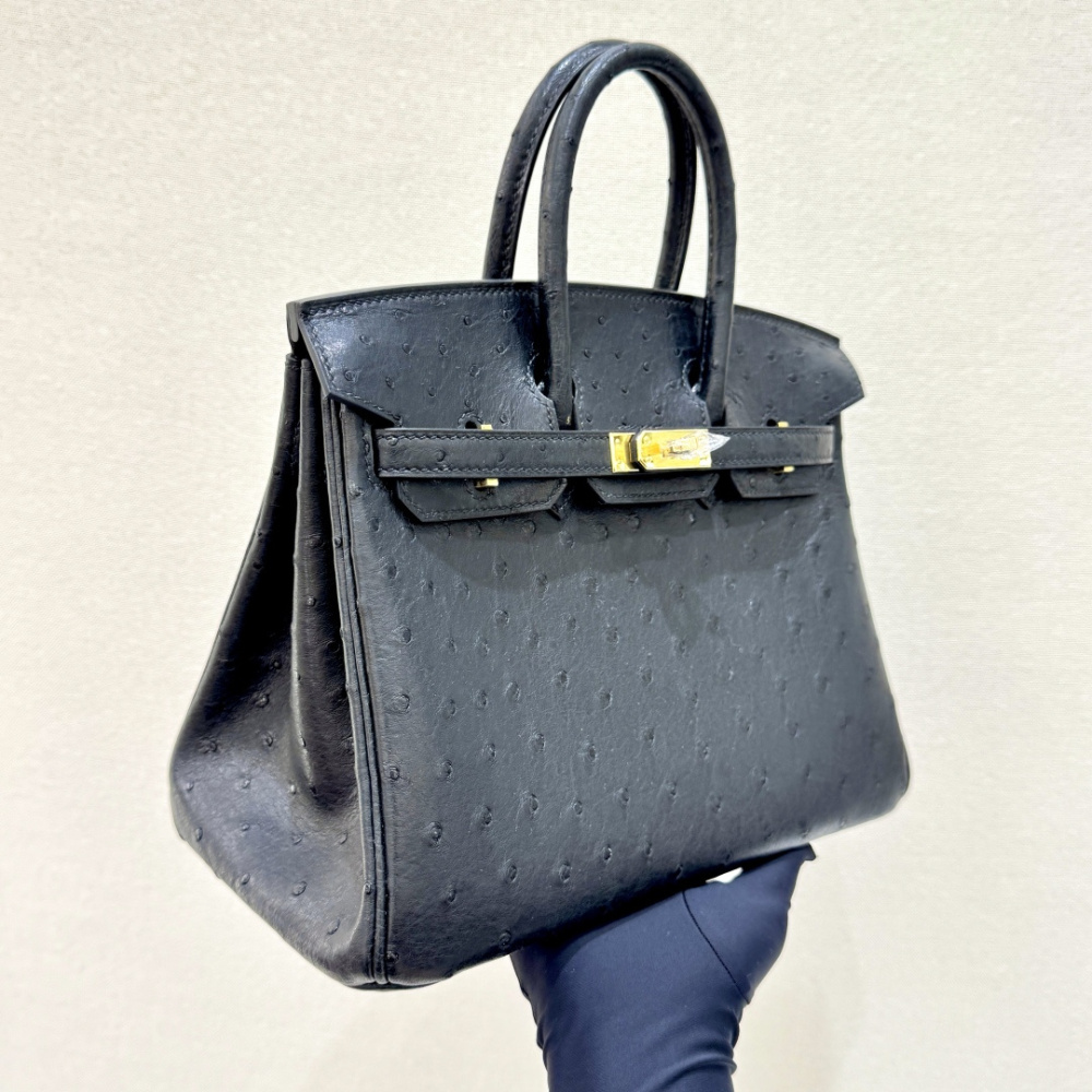 The Hermès Birkin 30 handbag in ostrich leather—featuring the classic black hue paired with gold hardware—is recognized by the brand as one of its "kings of value retention" among exotic skins.