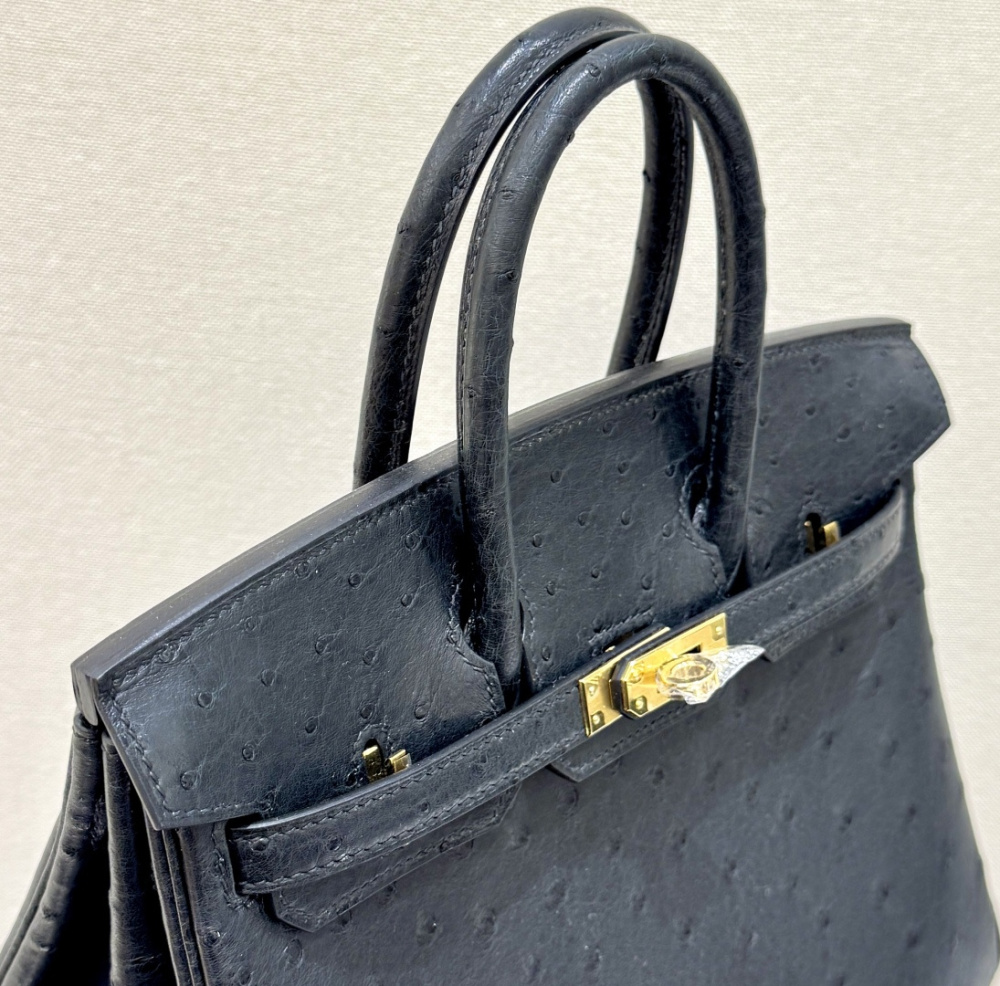 The Hermès Birkin 30 handbag in ostrich leather—featuring the classic black hue paired with gold hardware—is recognized by the brand as one of its "kings of value retention" among exotic skins.