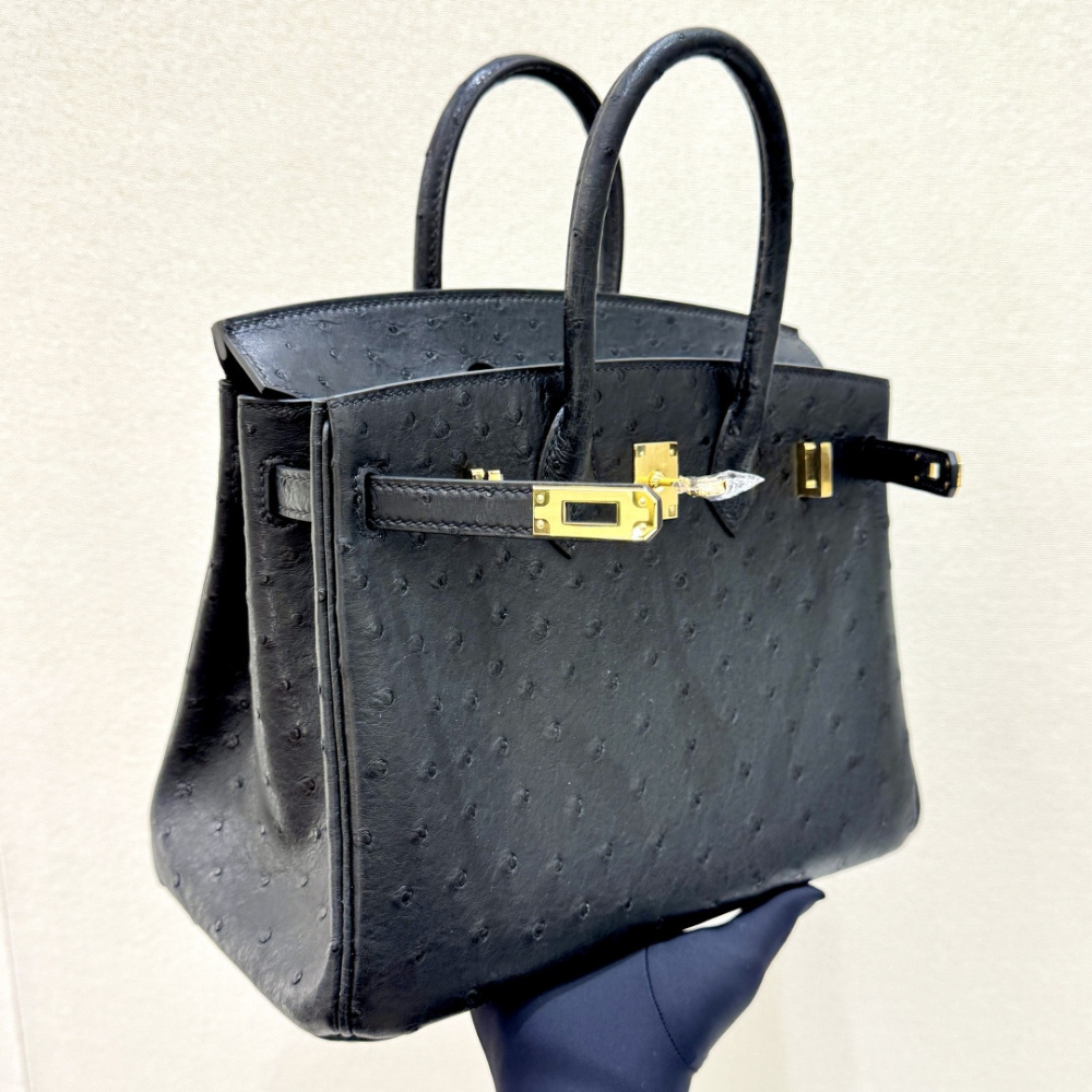 The Hermès Birkin 30 handbag in ostrich leather—featuring the classic black hue paired with gold hardware—is recognized by the brand as one of its "kings of value retention" among exotic skins.