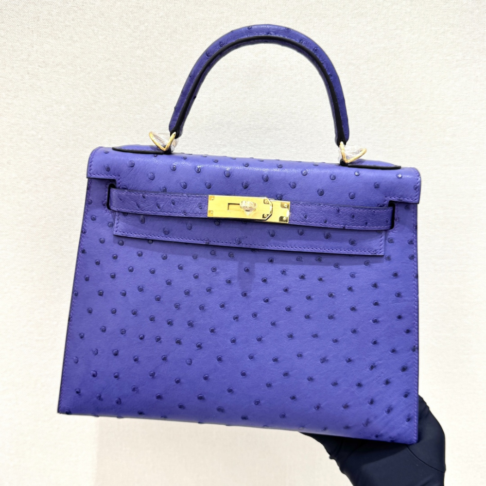 The Hermès Mini Kelly II handbag in ostrich leather—featuring a striking shade of purple (Iris/Electric Purple) paired with gold hardware—stands out as a highly distinctive and exclusive piece among Hermès' rare-skin offerings.