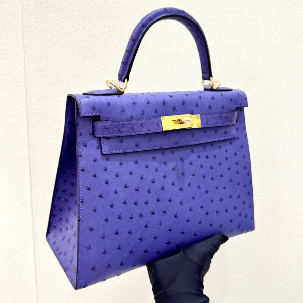 The Hermès Mini Kelly II handbag in ostrich leather—featuring a striking shade of purple (Iris/Electric Purple) paired with gold hardware—stands out as a highly distinctive and exclusive piece among Hermès' rare-skin offerings.