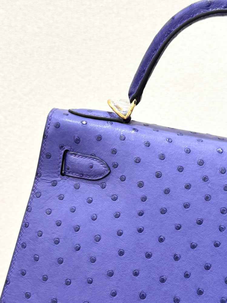 The Hermès Mini Kelly II handbag in ostrich leather—featuring a striking shade of purple (Iris/Electric Purple) paired with gold hardware—stands out as a highly distinctive and exclusive piece among Hermès' rare-skin offerings.