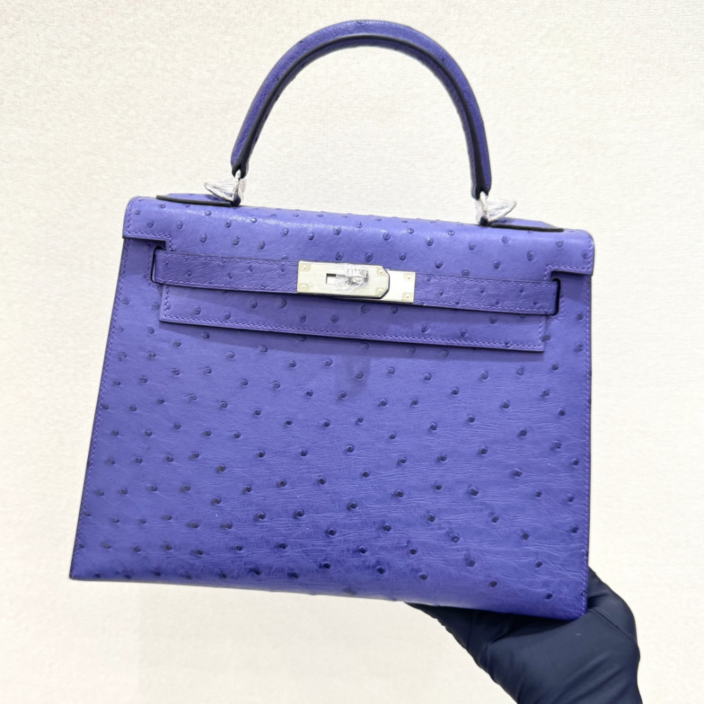 The Hermès Mini Kelly II handbag in ostrich leather—featuring a striking shade of purple (Iris/Electric Purple) paired with gold hardware—stands out as a highly distinctive and exclusive piece among Hermès' rare-skin offerings.