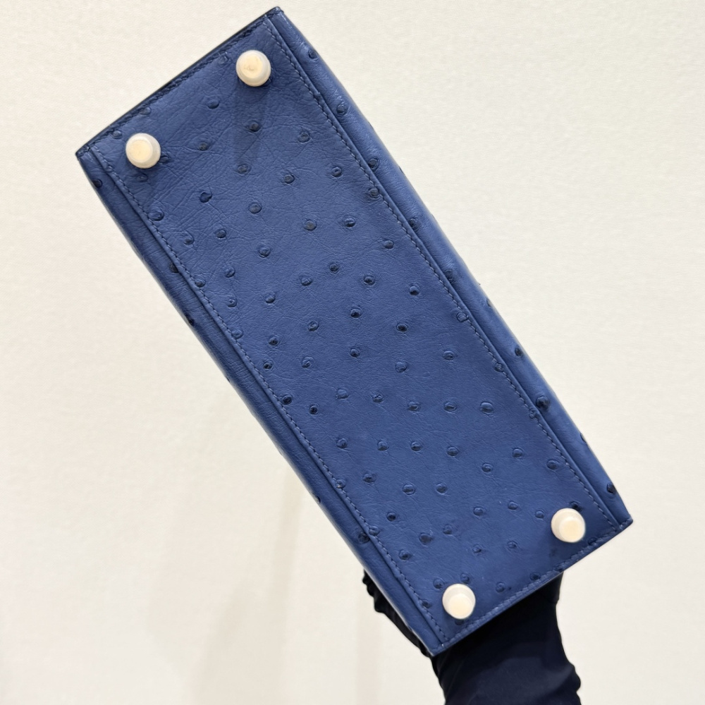 The Hermès Kelly 25 handbag in ostrich leather—featuring a fresh "Haze Blue" hue (also known as "Sailor Blue" or "Atlantic Blue") paired with gold hardware—stands as a quintessential example of Hermès' exotic skins, embodying an aesthetic that is both coo