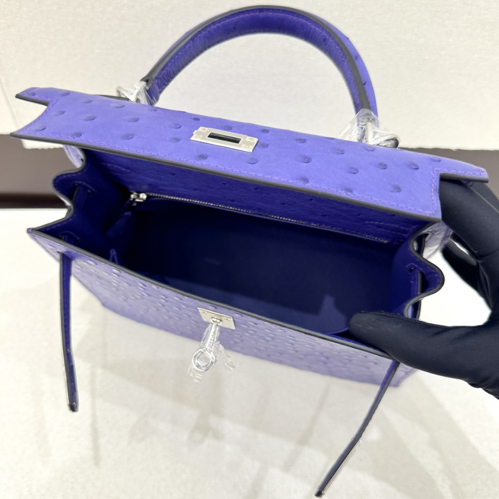 The Hermès Kelly 25 handbag in ostrich leather—featuring a striking electric purple (Iris/Lavender) hue paired with silver hardware—stands as an iconic representative among Hermès' exotic skins, distinguished by its exceptional individuality and artistic