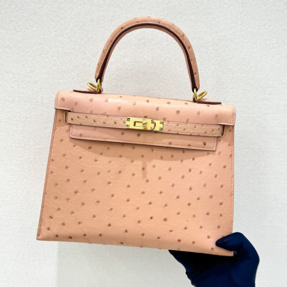 The Hermès Kelly 25 handbag in Ostrich leather—featuring a soft "Sakura Pink" hue (also known as "Nude Pink" or "Baby Pink") paired with gold hardware—is a highly sought-after model among Hermès exotic skins, perfectly blending a youthful, girlish charm w