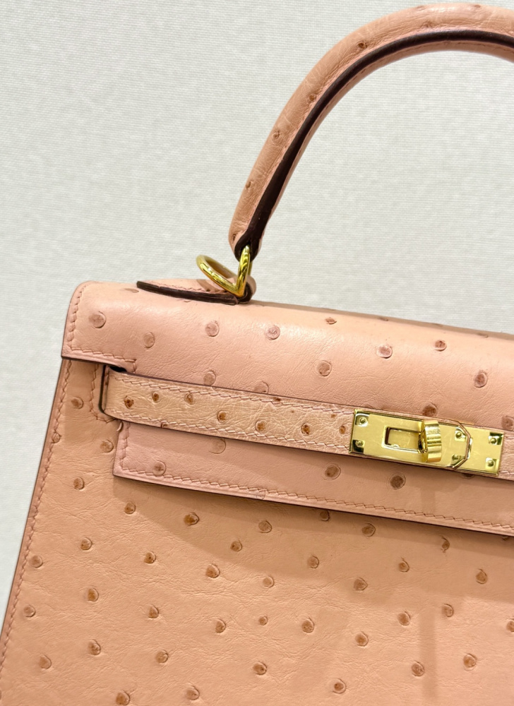 The Hermès Kelly 25 handbag in Ostrich leather—featuring a soft "Sakura Pink" hue (also known as "Nude Pink" or "Baby Pink") paired with gold hardware—is a highly sought-after model among Hermès exotic skins, perfectly blending a youthful, girlish charm w