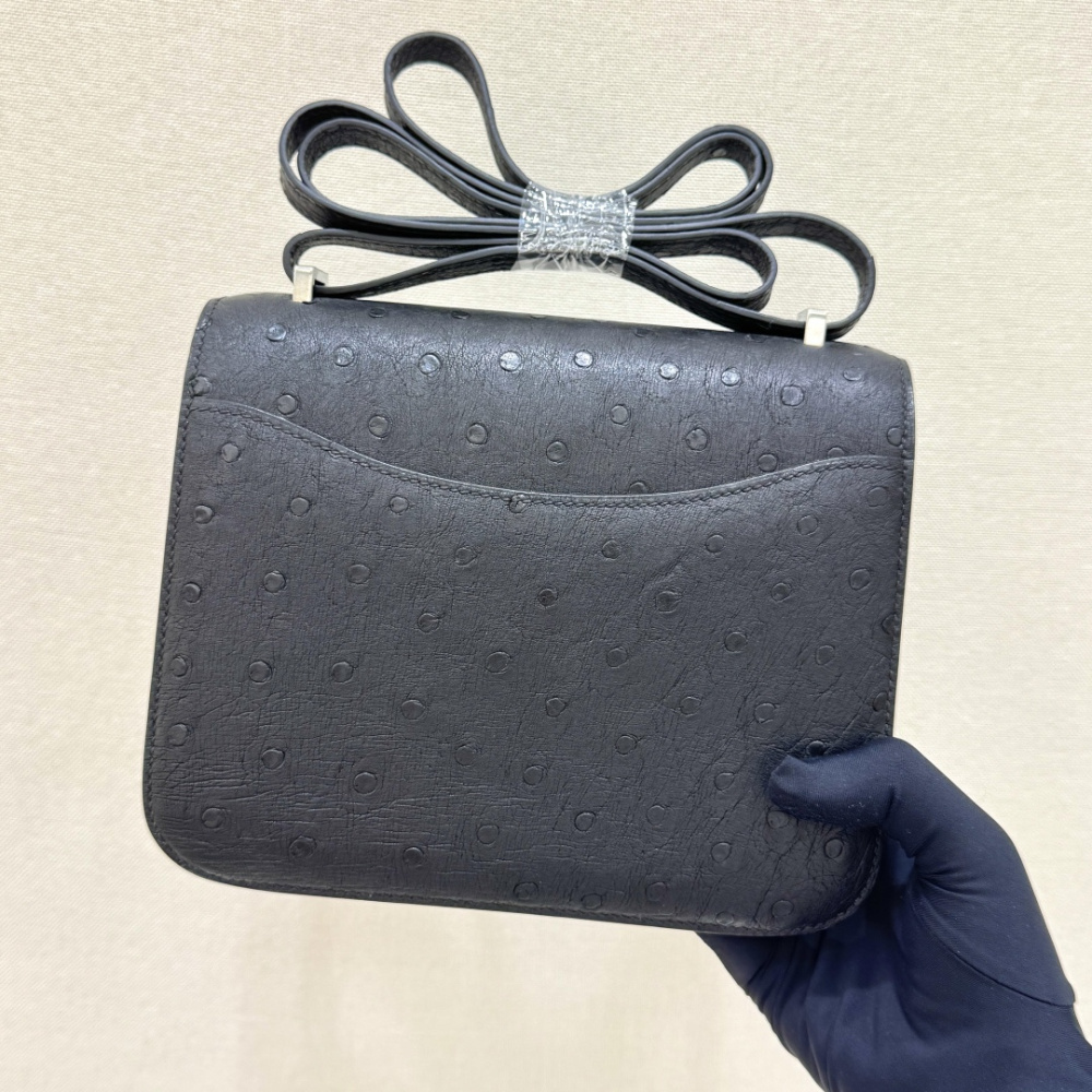 The Hermès Constance 19 handbag in ostrich leather—featuring classic black paired with silver hardware—stands as an understated yet highly recognizable icon within the brand's rare skins collection.