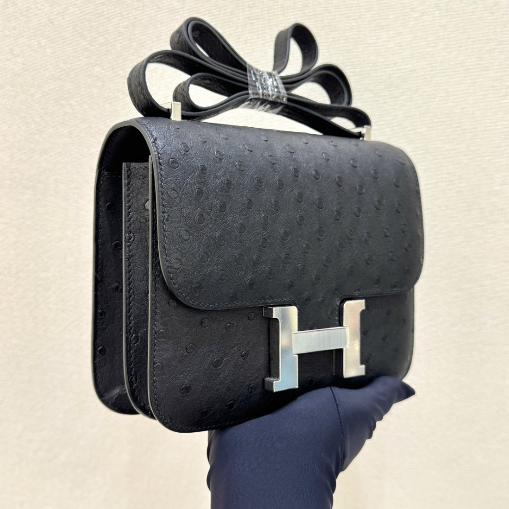 The Hermès Constance 19 handbag in ostrich leather—featuring classic black paired with silver hardware—stands as an understated yet highly recognizable icon within the brand's rare skins collection.