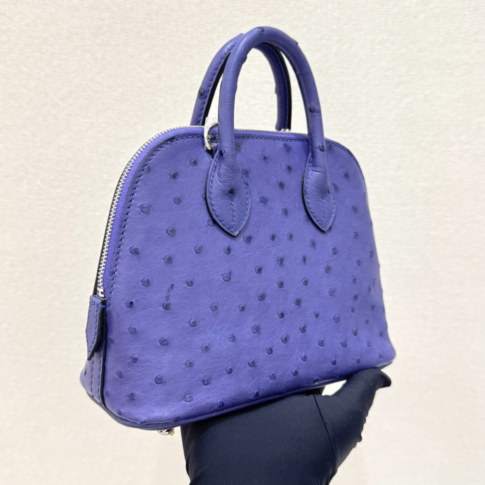 The Hermès Mini Bolide handbag in ostrich leather—featuring a striking Iris (Electric Purple) hue paired with silver hardware—stands as a highly distinctive, niche piece within Hermès' rare leather collection.