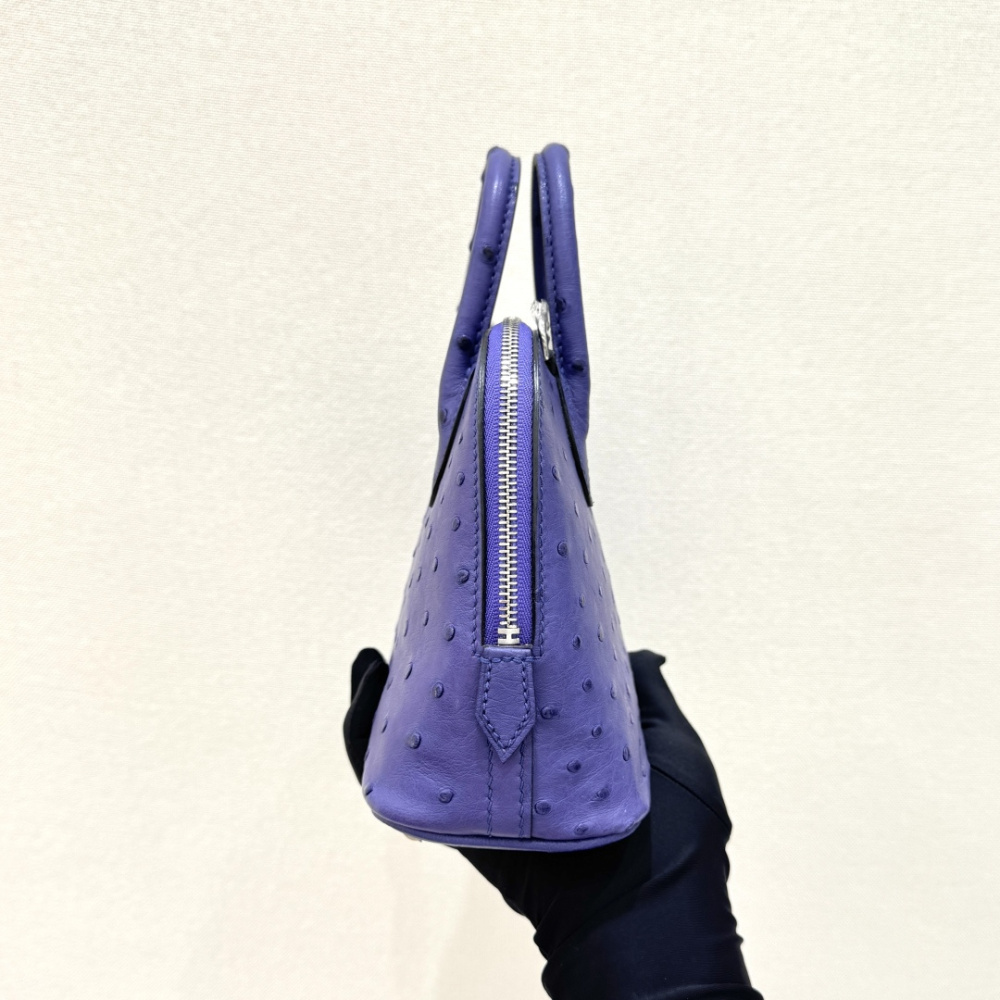 The Hermès Mini Bolide handbag in ostrich leather—featuring a striking Iris (Electric Purple) hue paired with silver hardware—stands as a highly distinctive, niche piece within Hermès' rare leather collection.