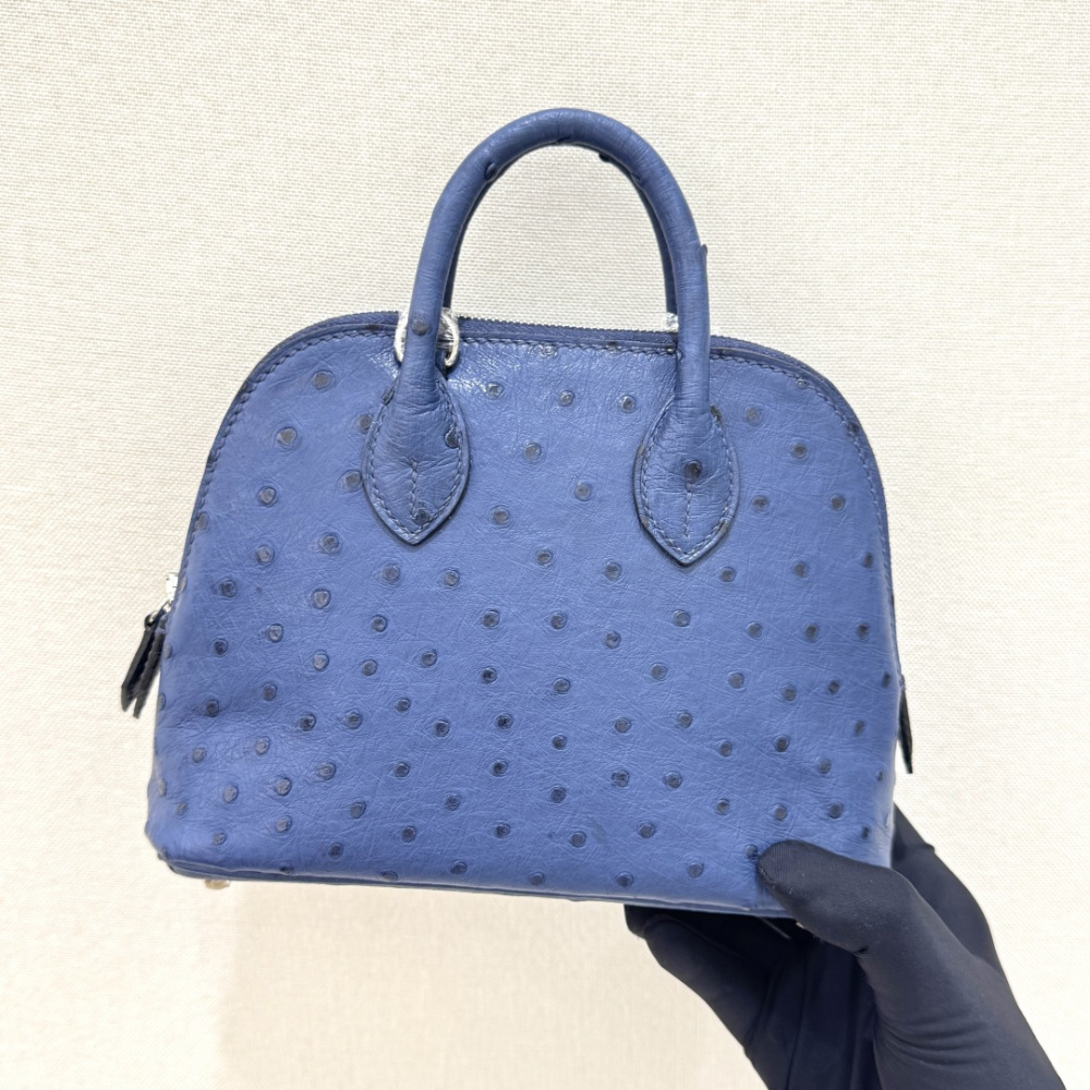The Hermès Mini Bolide handbag in ostrich leather—featuring a "Haze Blue" (Sailor Blue / Atlantic Blue) hue paired with silver hardware—is a fresh, practical, and highly sought-after piece within the brand's rare skins collection.
