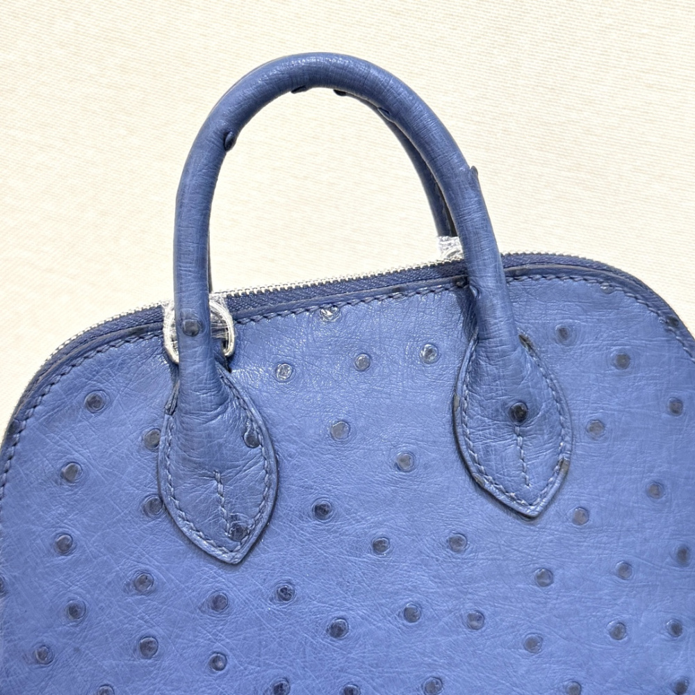 The Hermès Mini Bolide handbag in ostrich leather—featuring a "Haze Blue" (Sailor Blue / Atlantic Blue) hue paired with silver hardware—is a fresh, practical, and highly sought-after piece within the brand's rare skins collection.