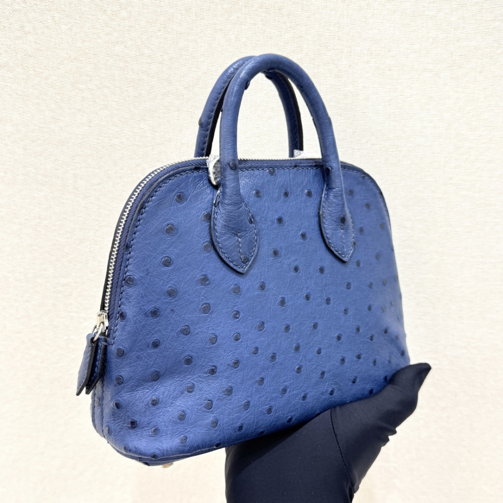 The Hermès Mini Bolide handbag in ostrich leather—featuring a "Haze Blue" (Sailor Blue / Atlantic Blue) hue paired with silver hardware—is a fresh, practical, and highly sought-after piece within the brand's rare skins collection.