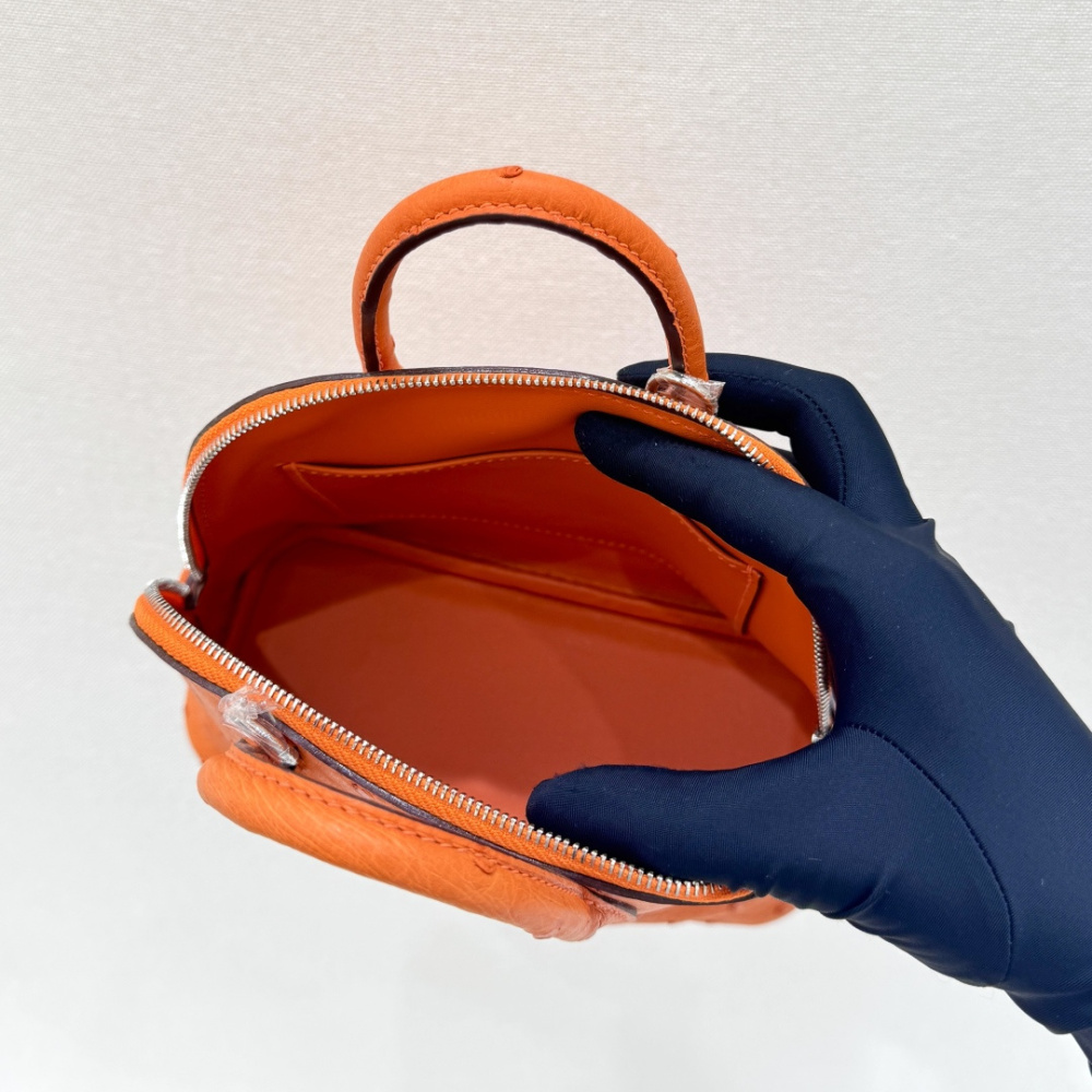 The Hermès Mini Bolide handbag in ostrich leather—featuring the classic Hermès Orange paired with silver hardware—is a highly recognizable and vibrant piece within the brand's exotic skins collection.