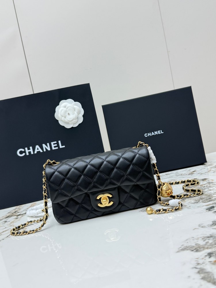 This is a small Chanel Classic Flap bag with a pearl crush charm (often referred to as the "Golden Ball CF") from Chanel, featuring the brand's iconic lambskin and diamond-quilted pattern.