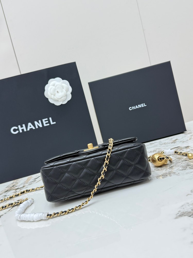 This is a small Chanel Classic Flap bag with a pearl crush charm (often referred to as the "Golden Ball CF") from Chanel, featuring the brand's iconic lambskin and diamond-quilted pattern.