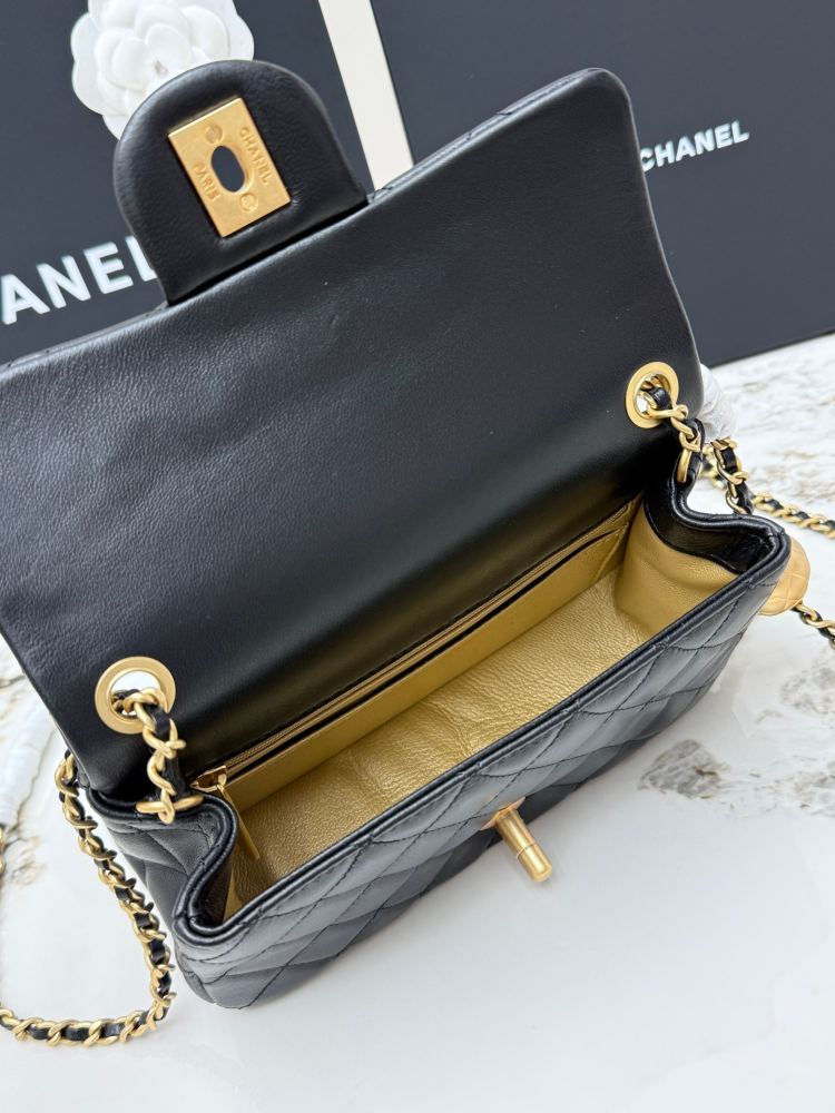 This is a small Chanel Classic Flap bag with a pearl crush charm (often referred to as the "Golden Ball CF") from Chanel, featuring the brand's iconic lambskin and diamond-quilted pattern.