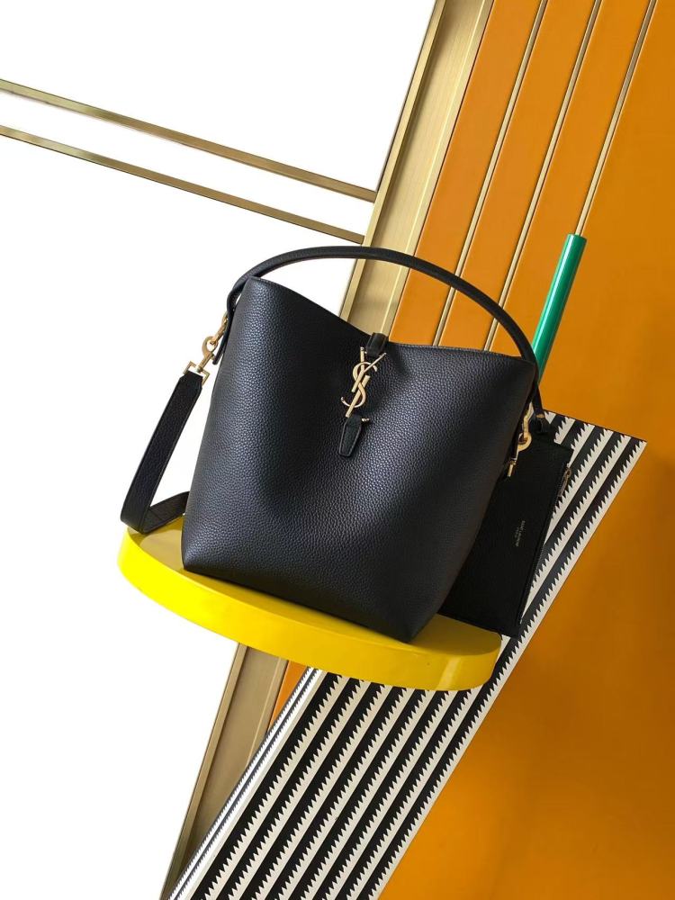 This is a bucket bag from Yves Saint Laurent (YSL), crafted in black grained leather with a gold-tone YSL logo hardware. It comes with a detachable pouch and strap, suitable for both hand-held and crossbody wear.