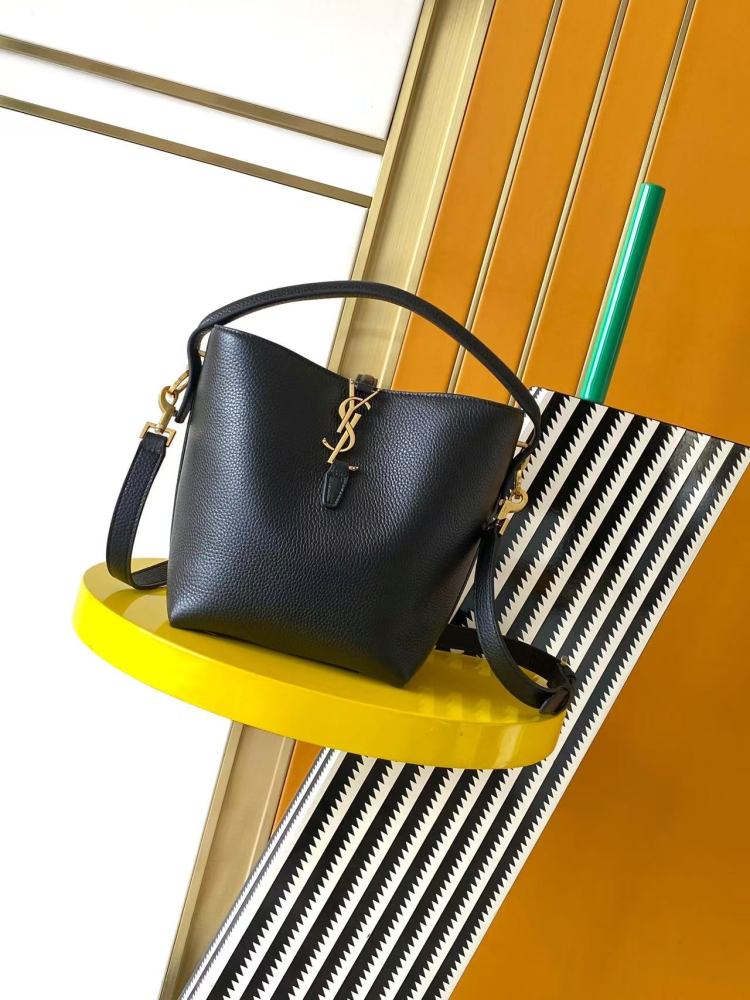 This is a small bucket bag from Yves Saint Laurent (YSL), crafted in black grained leather with a gold-tone YSL logo hardware. It comes with a detachable strap, suitable for both hand-held and crossbody wear.