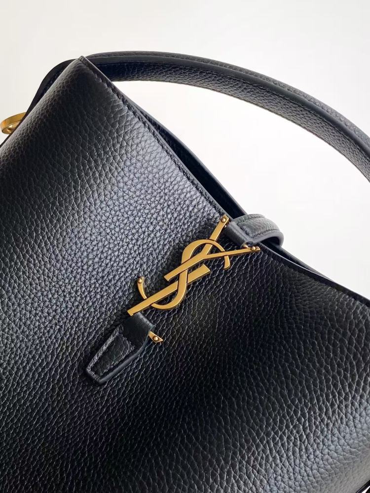 This is a small bucket bag from Yves Saint Laurent (YSL), crafted in black grained leather with a gold-tone YSL logo hardware. It comes with a detachable strap, suitable for both hand-held and crossbody wear.