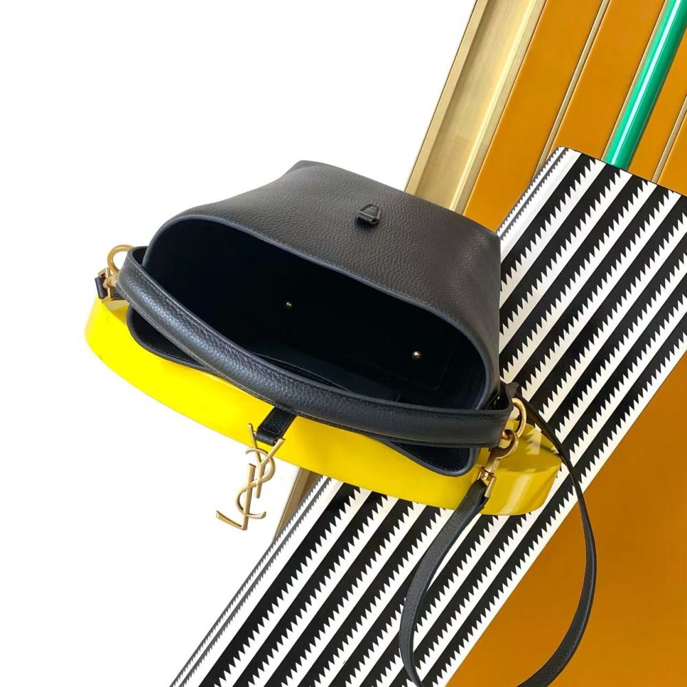 This is a small bucket bag from Yves Saint Laurent (YSL), crafted in black grained leather with a gold-tone YSL logo hardware. It comes with a detachable strap, suitable for both hand-held and crossbody wear.