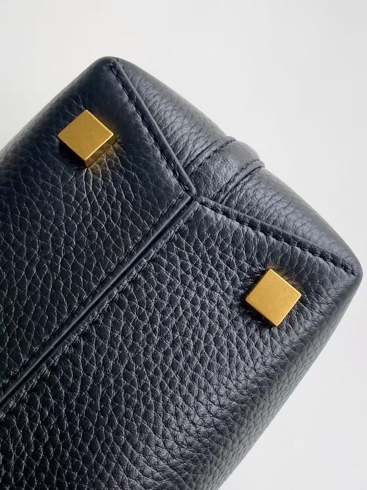 This is a bucket bag from Yves Saint Laurent (YSL), crafted in black grained leather. The front of the bag is adorned with a prominent gold-tone YSL logo hardware. It comes with a detachable short top handle and a long crossbody strap, allowing for multip