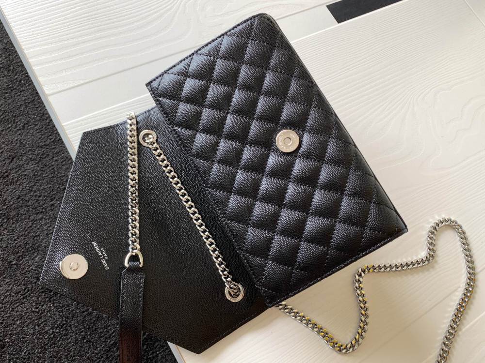 This is a classic Yves Saint Laurent shoulder bag, crafted from black caviar-textured leather and adorned on the front with striking gold-tone hardware featuring the iconic YSL logo.