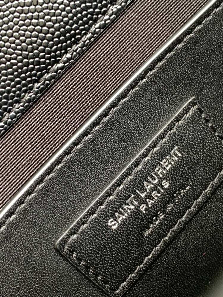This is a classic Yves Saint Laurent shoulder bag, crafted from black caviar-textured leather and adorned on the front with striking gold-tone hardware featuring the iconic YSL logo.