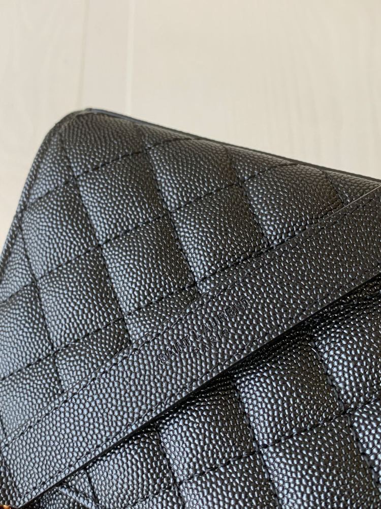 This is a quilted envelope bag from YSL, crafted in black caviar leather with a gold-tone logo and metal chain strap, suitable for shoulder or crossbody wear.
