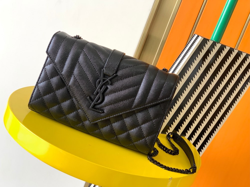 This is a quilted envelope bag from YSL, crafted in black caviar leather with a matching black logo and metal chain strap, suitable for shoulder or crossbody wear.