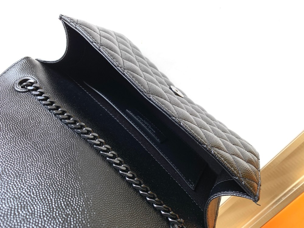 This is a quilted envelope bag from YSL, crafted in black caviar leather with a matching black logo and metal chain strap, suitable for shoulder or crossbody wear.