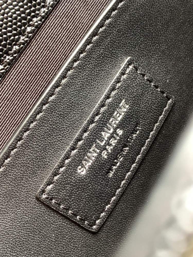 This is a quilted envelope bag from YSL, crafted in black caviar leather with a matching black logo and metal chain strap, suitable for shoulder or crossbody wear.