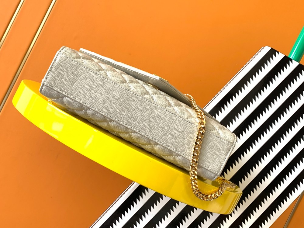 This is a quilted envelope bag from YSL, crafted in off-white caviar leather with a gold-tone logo and metal chain strap, suitable for shoulder or crossbody wear.