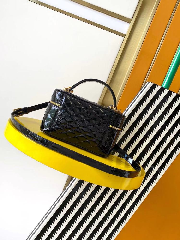 This is a quilted cosmetic bag from YSL, crafted in black patent leather with a gold-tone logo and detachable strap, suitable for hand-held or shoulder wear.