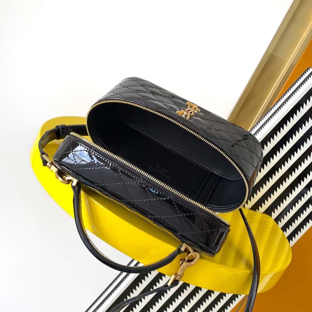 This is a quilted cosmetic bag from YSL, crafted in black patent leather with a gold-tone logo and detachable strap, suitable for hand-held or shoulder wear.