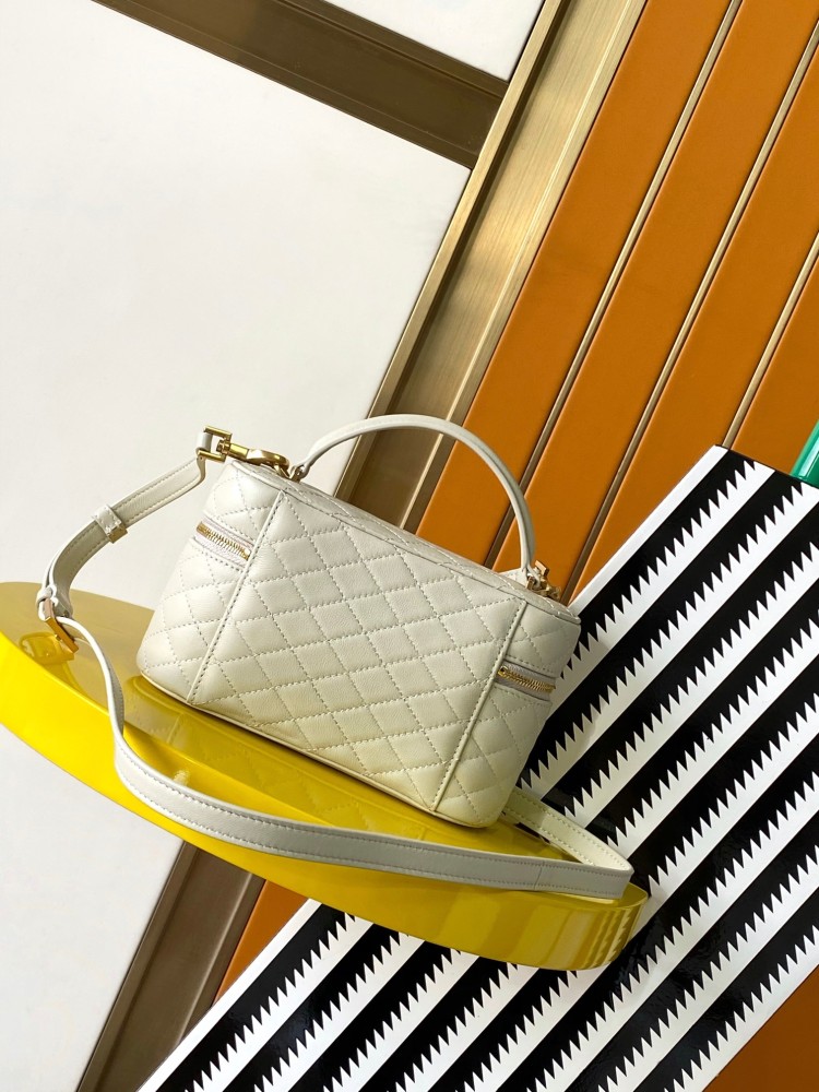 This is a quilted cosmetic bag from YSL, crafted in off-white grained leather with a gold-tone logo and detachable strap, suitable for hand-held or shoulder wear.